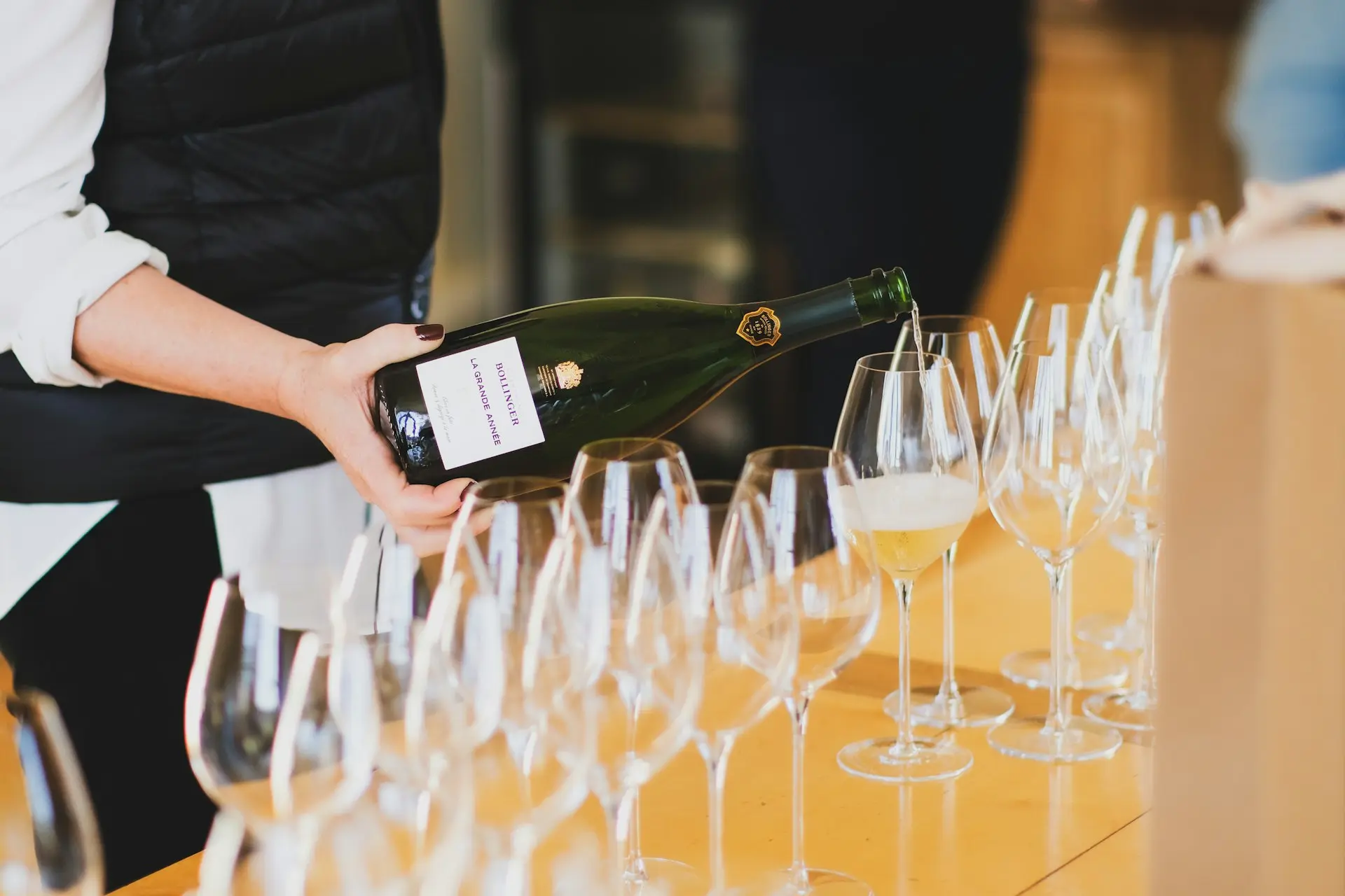 a person pouring wine into a wine glass